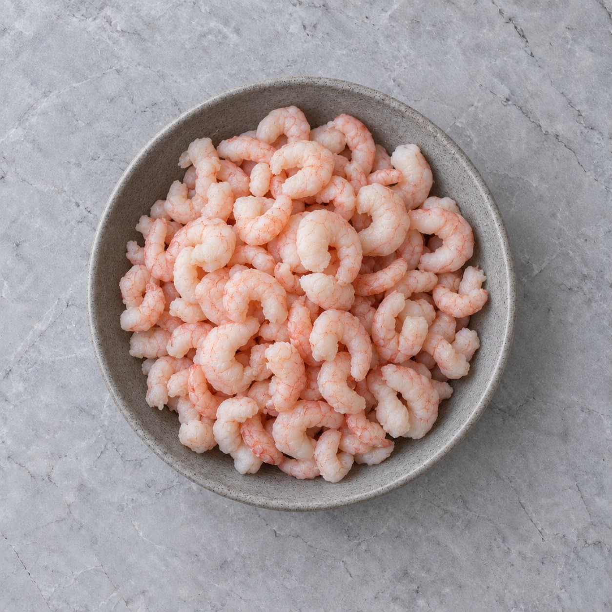 Cooked peeled prawns in a grey stoneware bowl